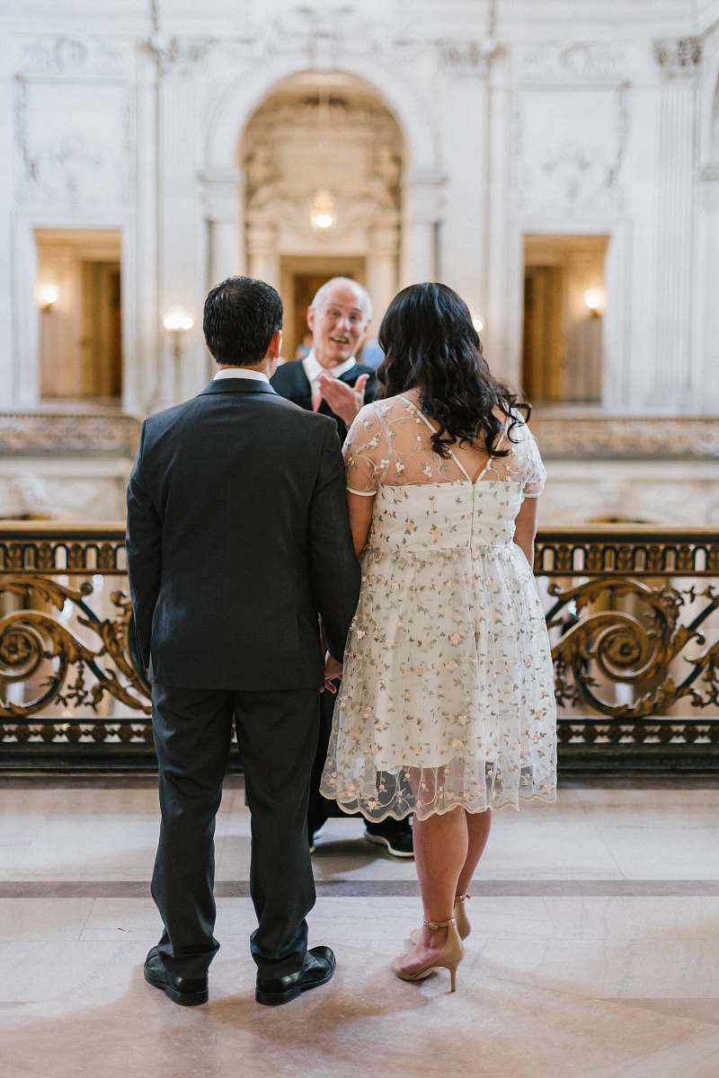 person man and woman standing in front of man wedding