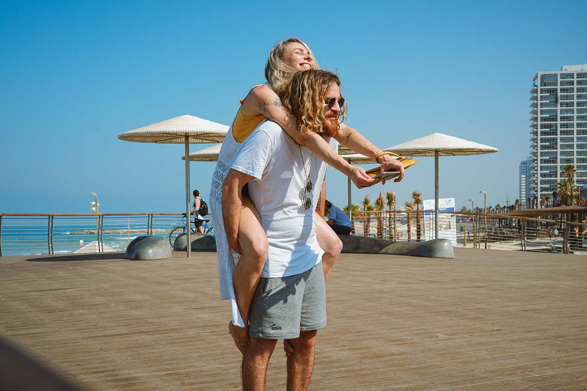 human man giving woman piggyback ride person