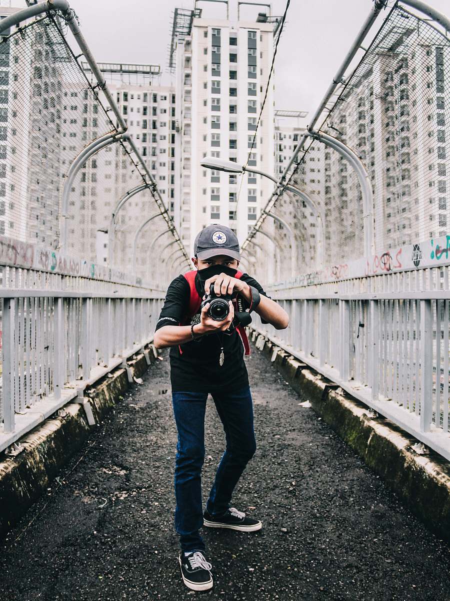 human man holding camera on pathway person