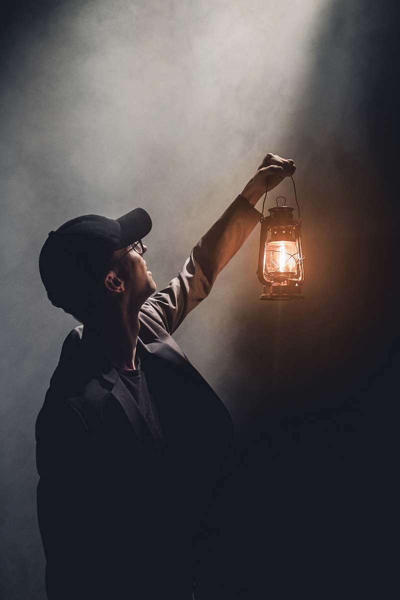 human man holding lighted gas lantern person