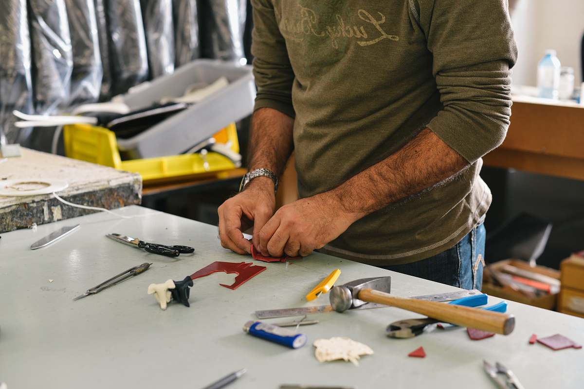 person man holding tool in front of table work