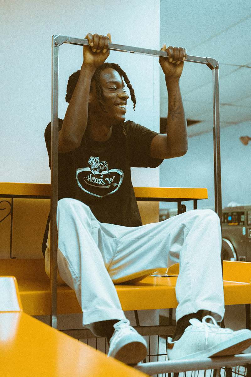 human man in black T-shirt and white pants sitting on table holding stainless steel bar person