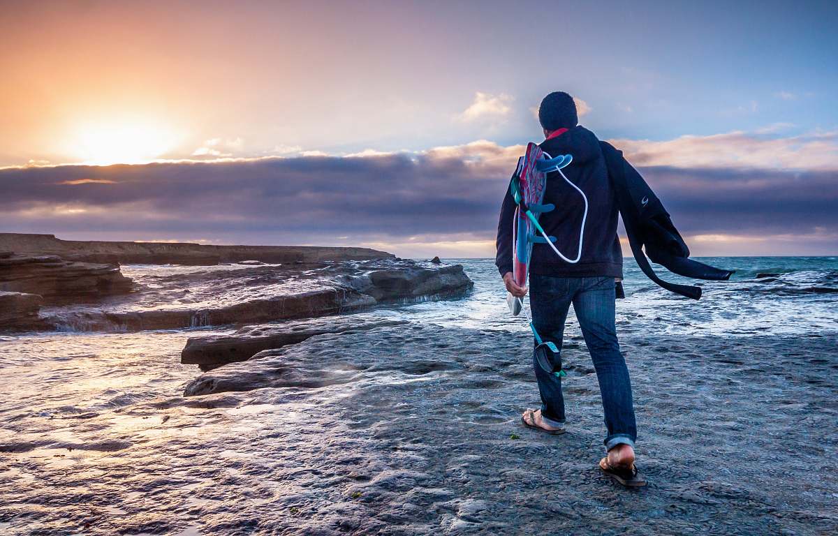 human man in blue jeans walking on gray soil ocean