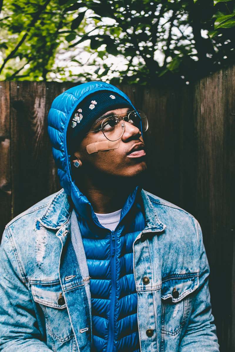 human man looking above wearing blue bubble jacket and blue denim jacket person