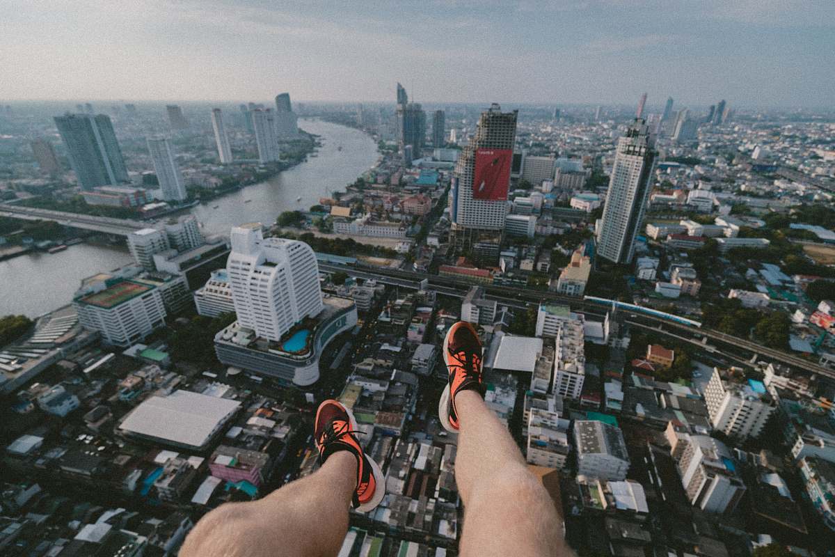 person man paragliding taking aerial photography of city scapes during daytime city