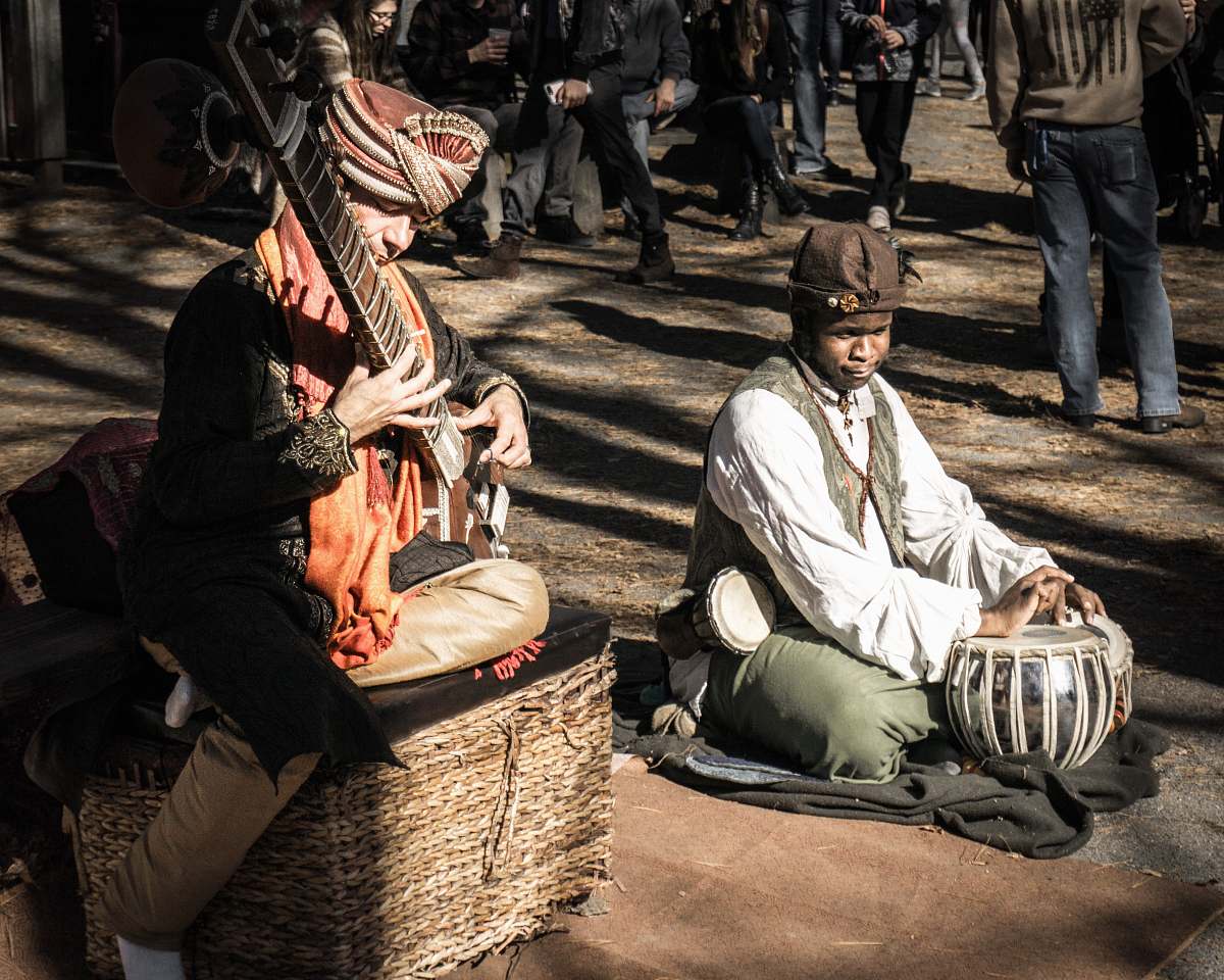 human man playing on stringed instrument sitting on brown wicker basket person