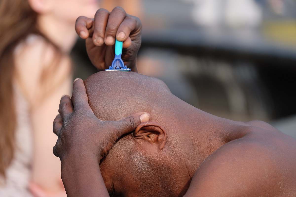 human man shaving his head person