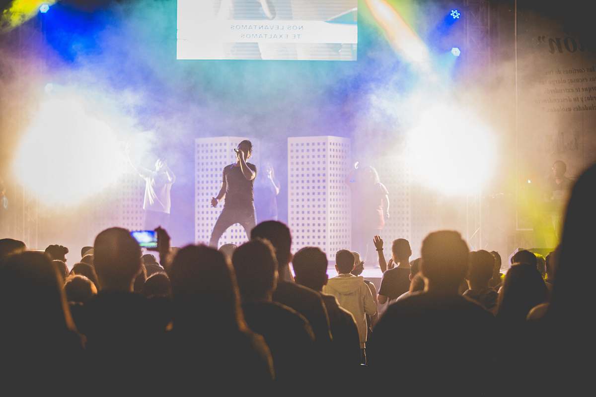 human man singing in concert surrounded by people person