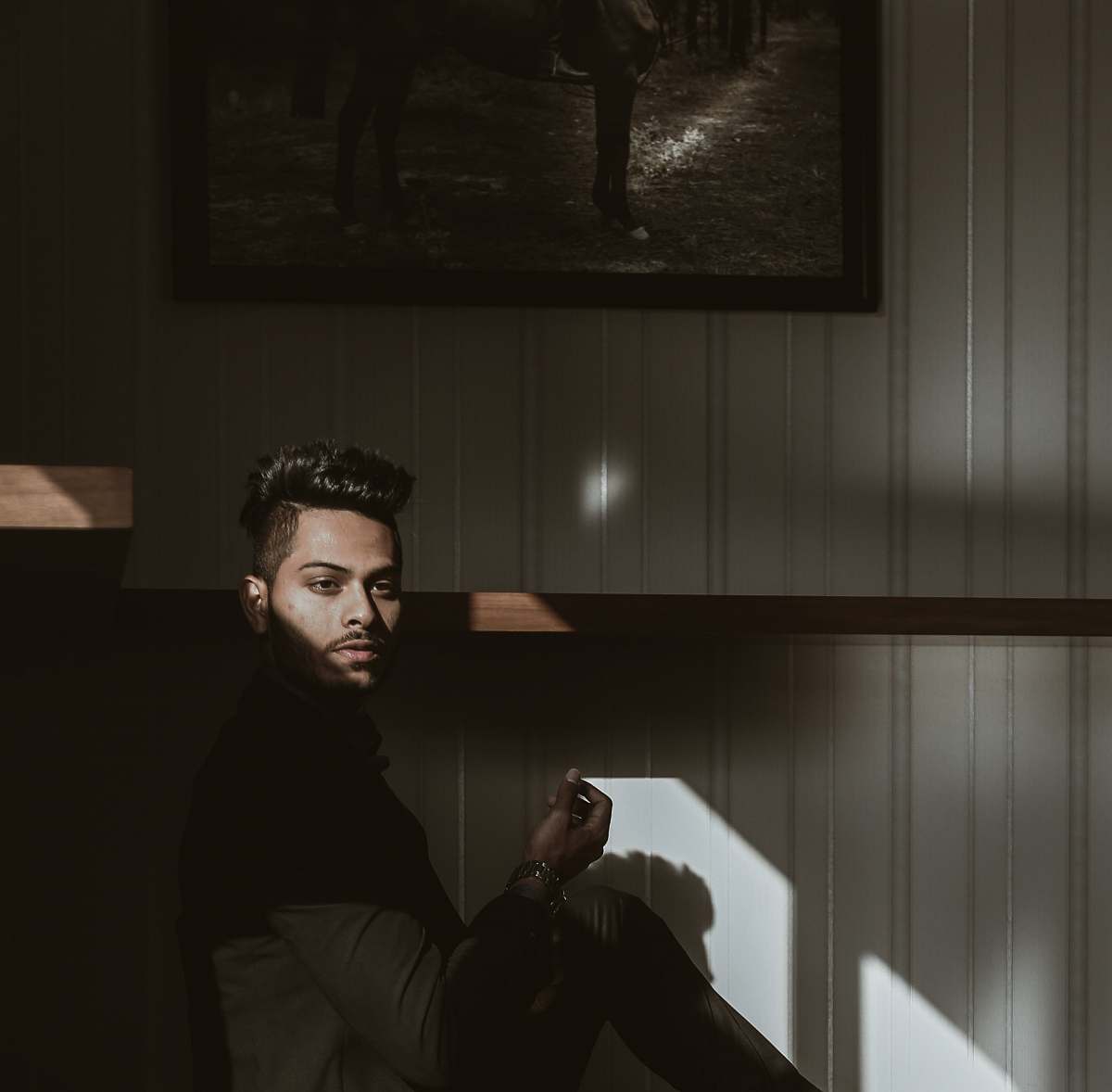 human man sitting beside painting person