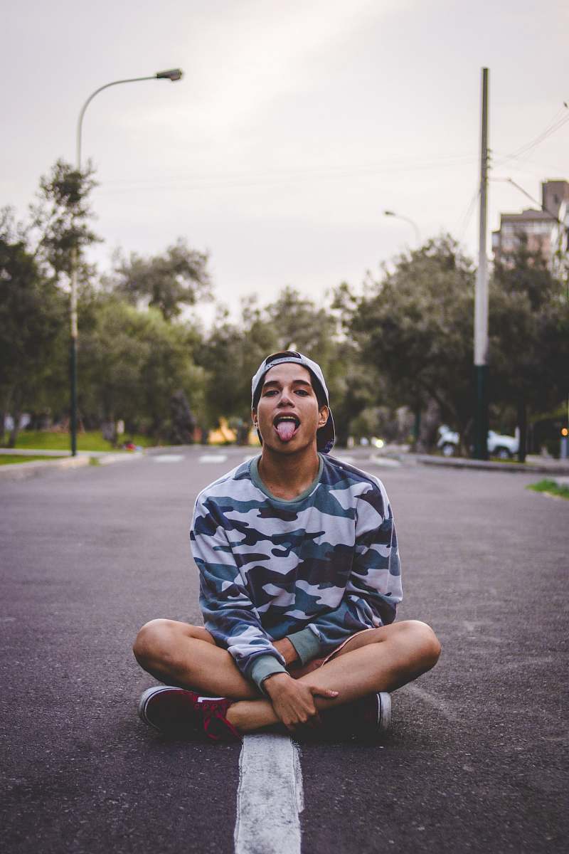 person man sitting on asphalt road human