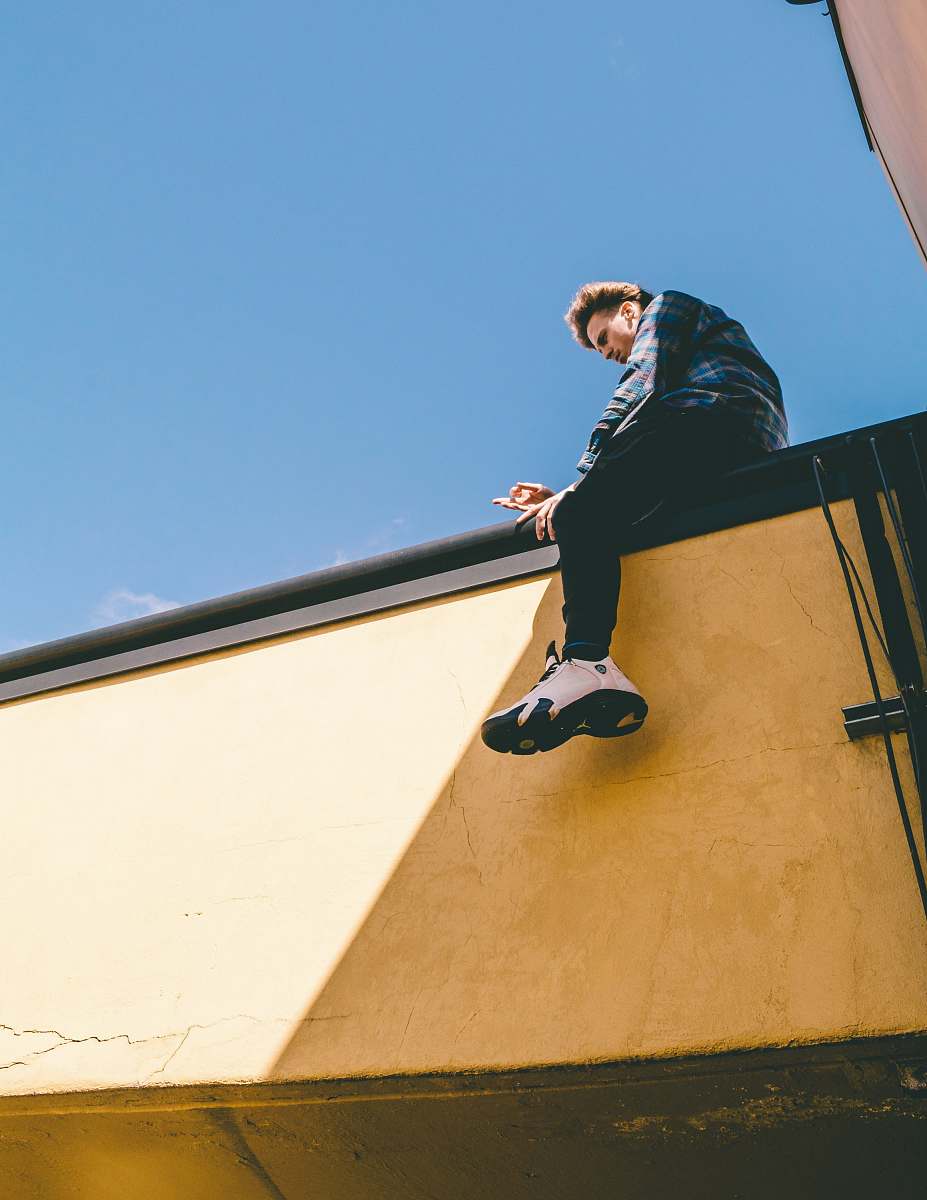 human man sitting on roof under blue sky person