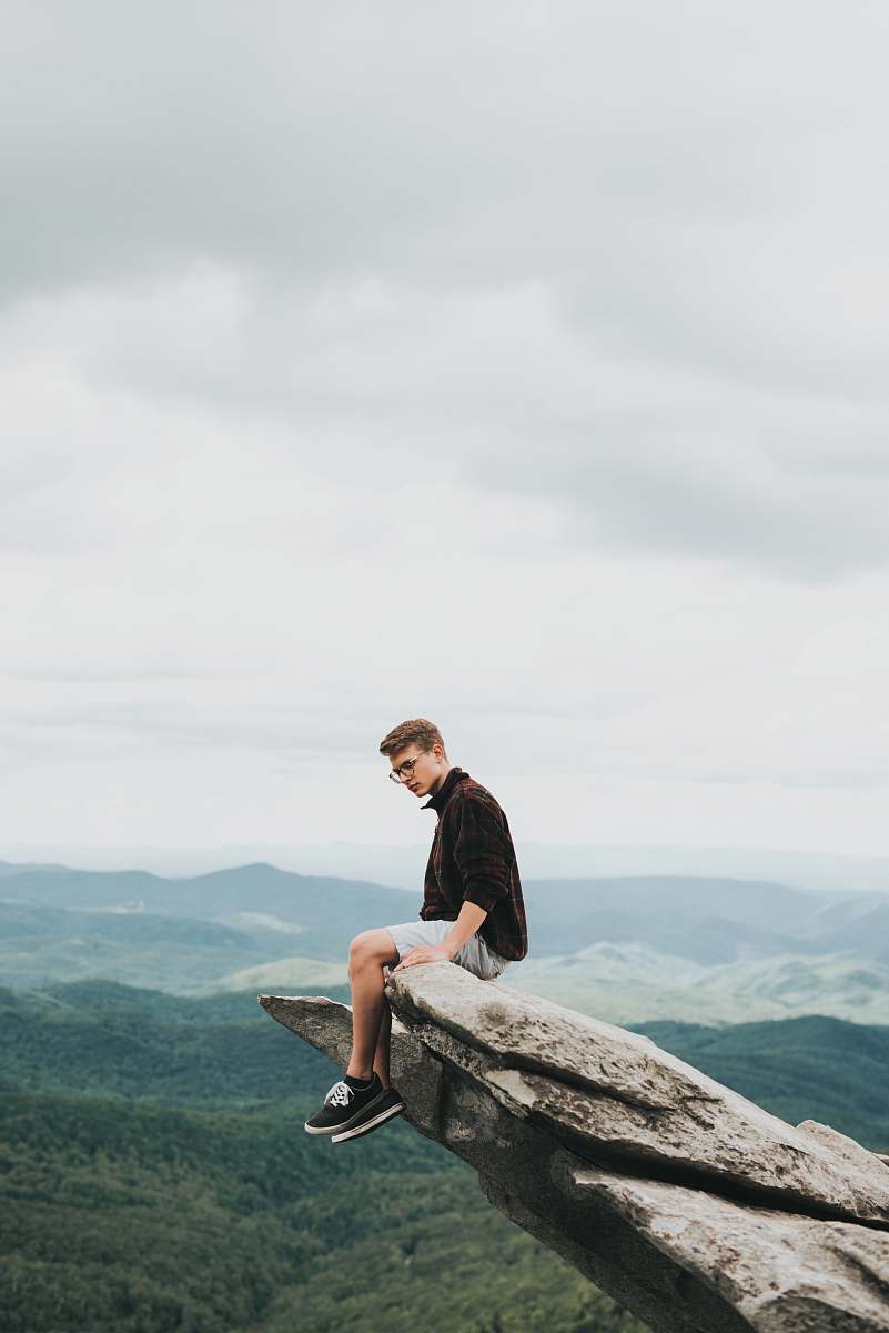 human man sitting on the edge of stone person