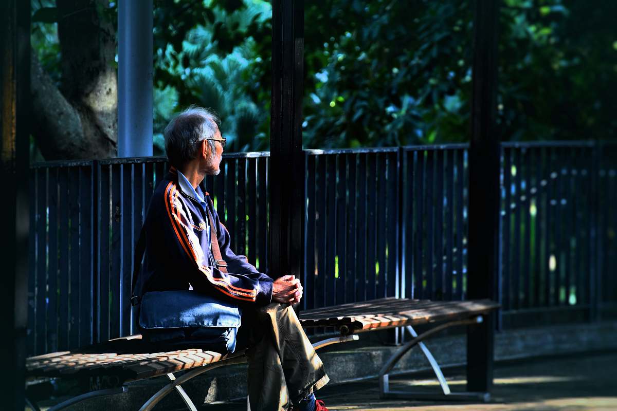 human man sitting on wooden bench person