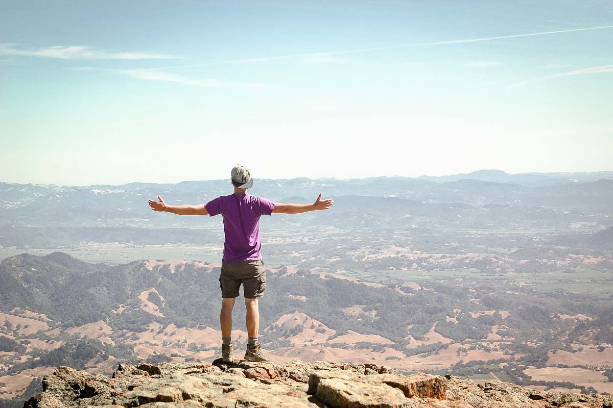 human man stand on brown mountain under blue sky person