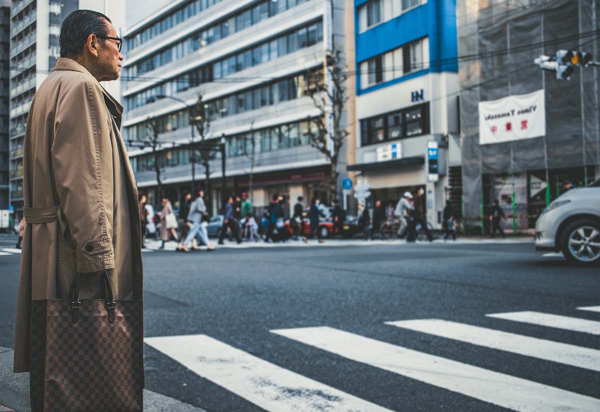 person man standing in front of concrete buildings human