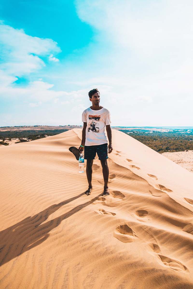 human man standing on desert mountain sand