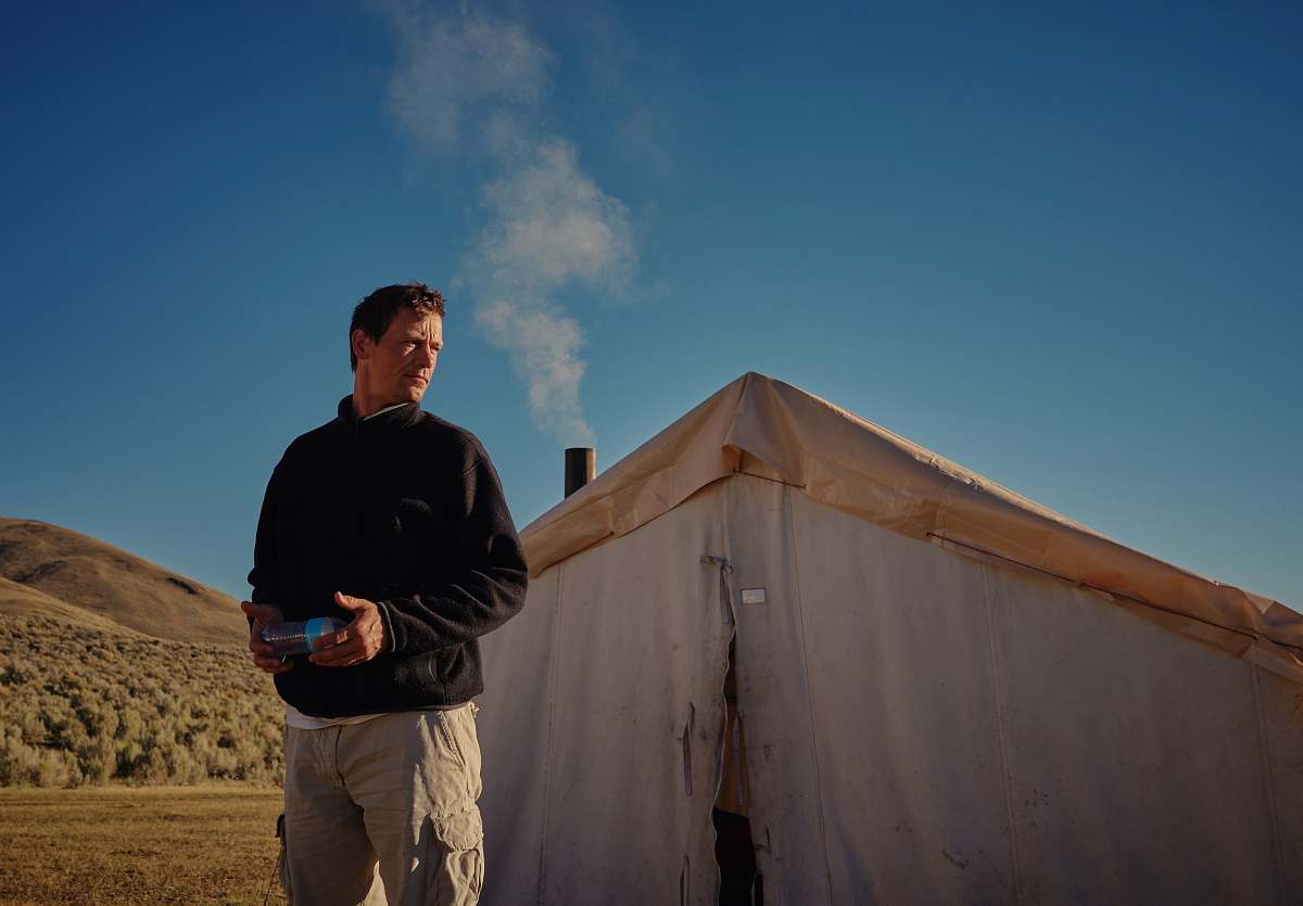 human man standing outside white tent person