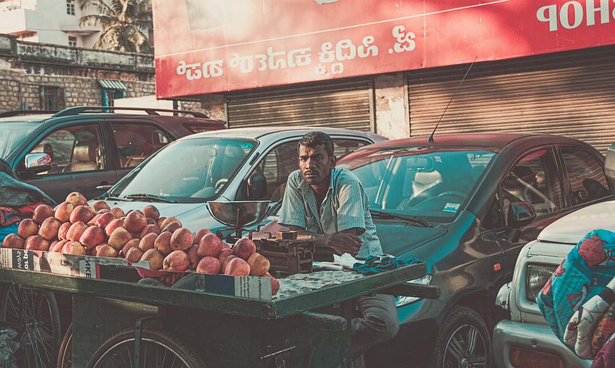 car man vending apples near parked cars during daytime vehicle