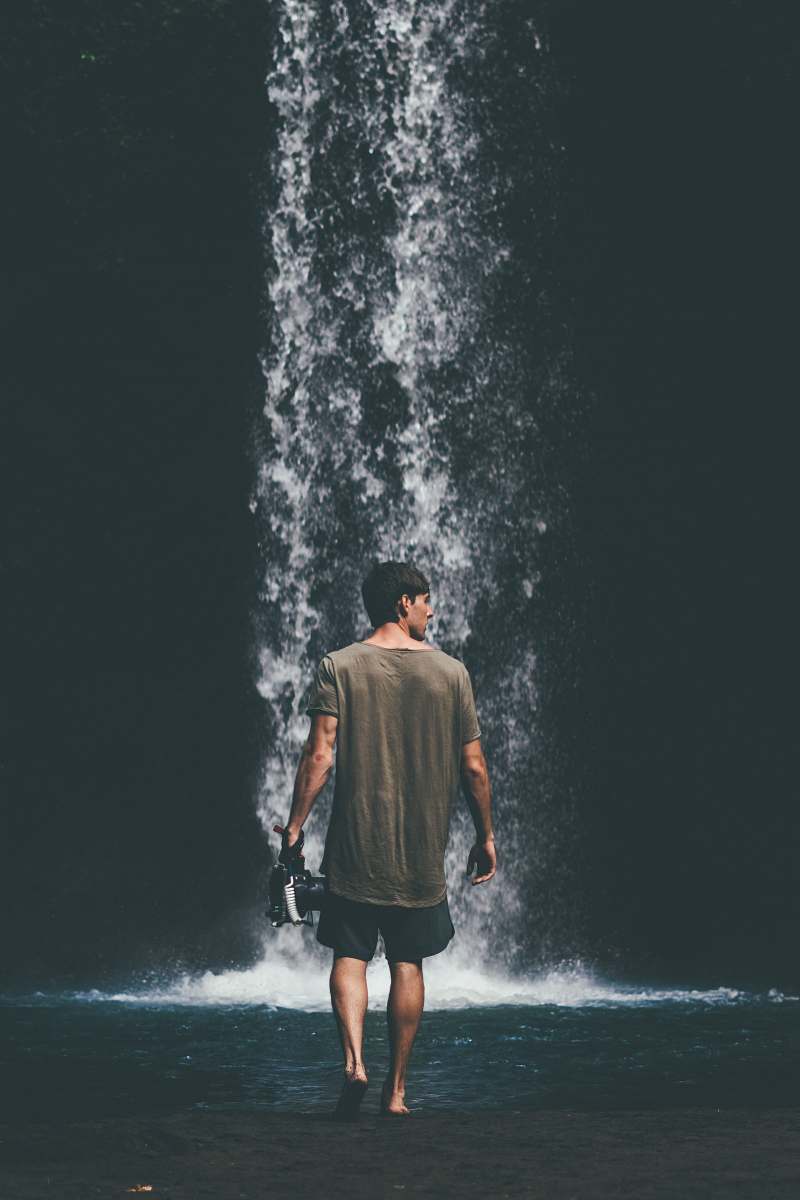 person man walking near waterfalls human