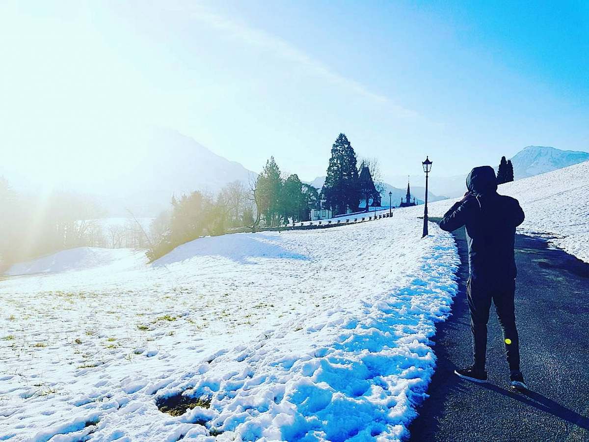 human man walking on path beside snow person