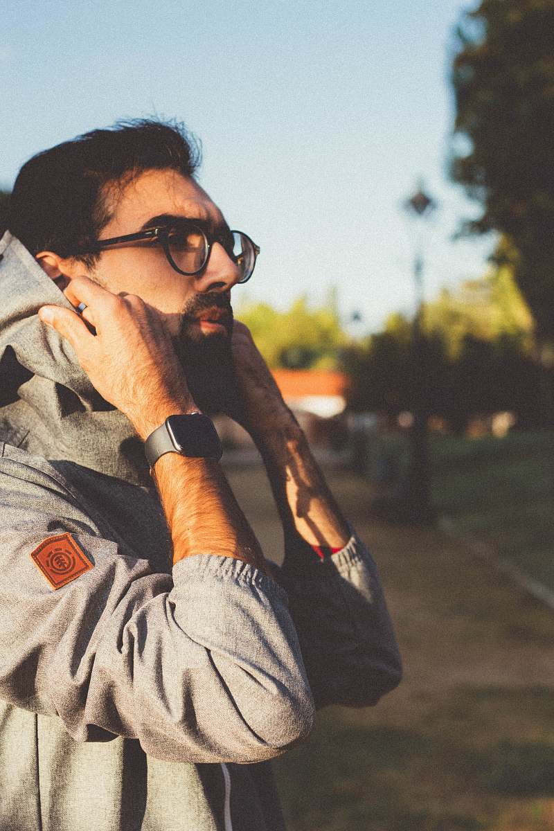 human man wearing black framed eyeglasses fixing hood person