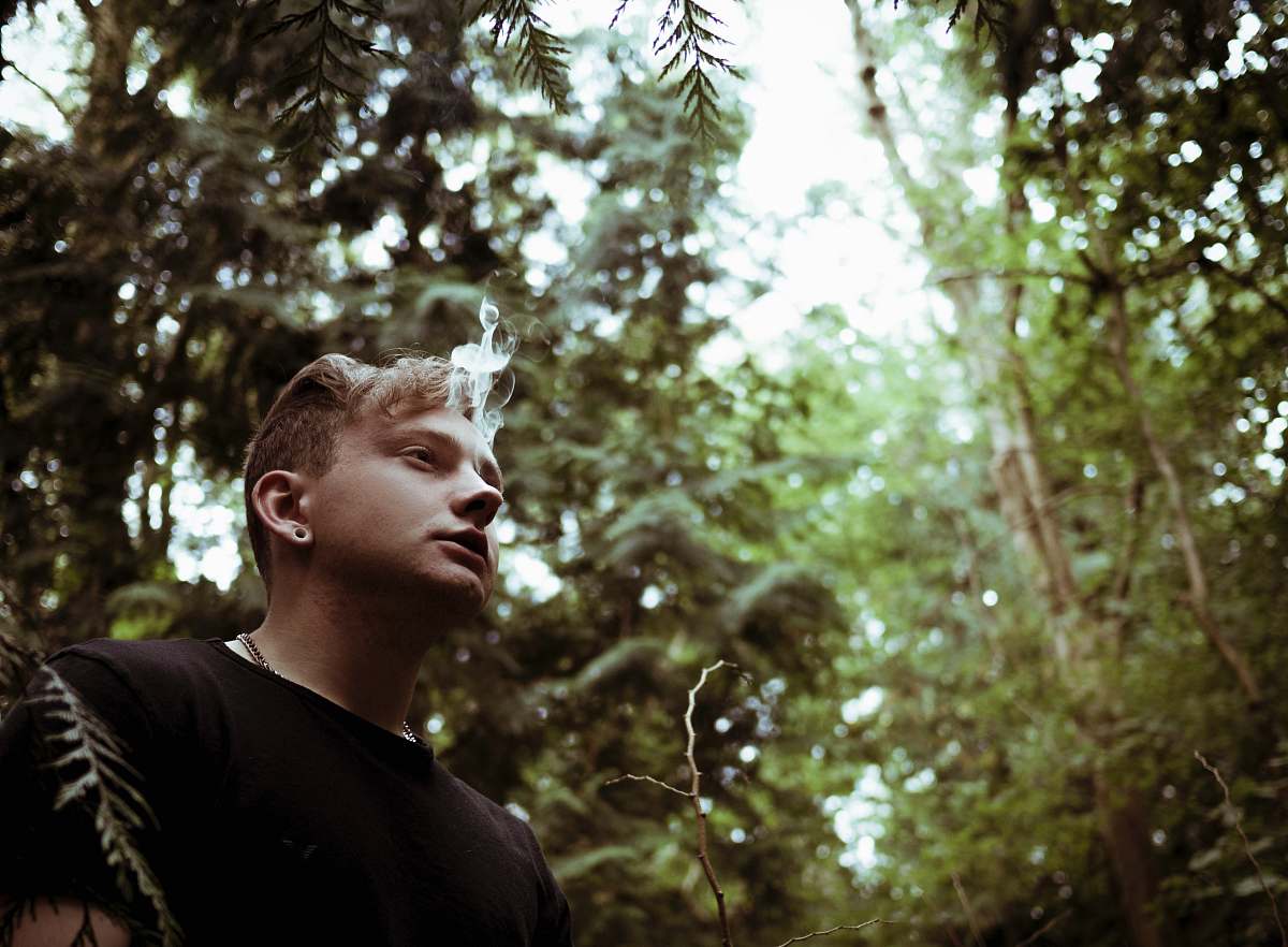 human man wearing black shirt and surrounded by trees person