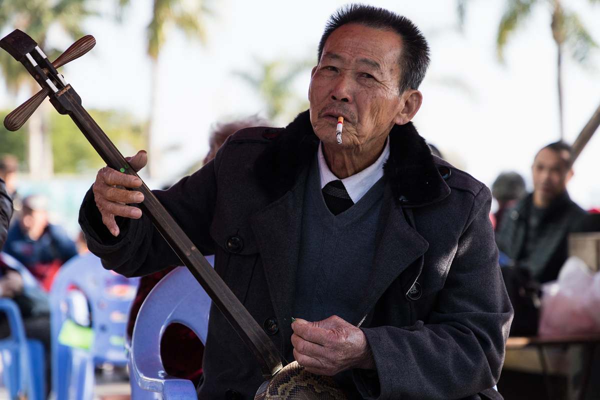 person man wearing black suit holding guitar while smoking human