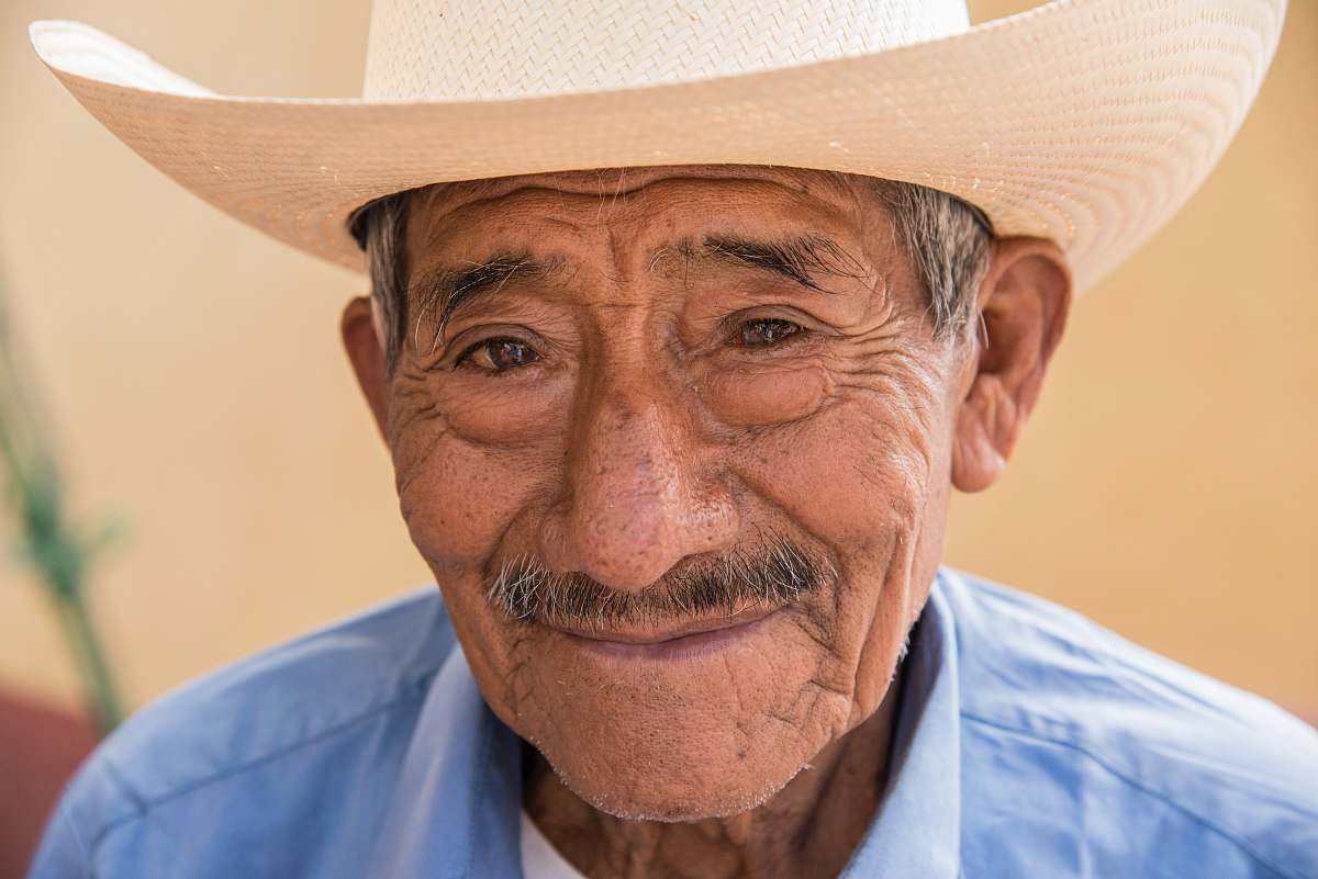 hat man wearing blue top clothing