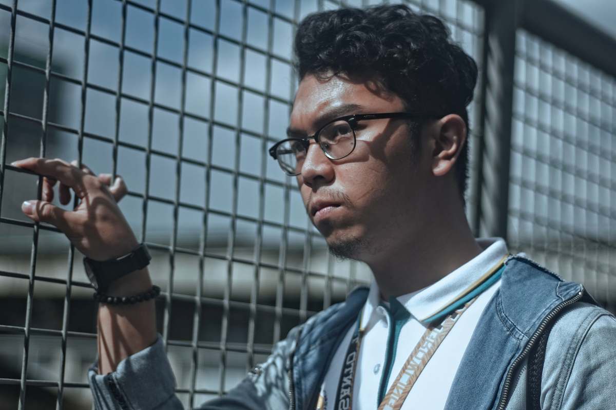 human man wearing eyeglasses near the fence person