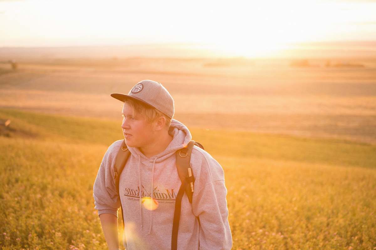 person man wearing gray pullover hoodie near green grass at daytime human