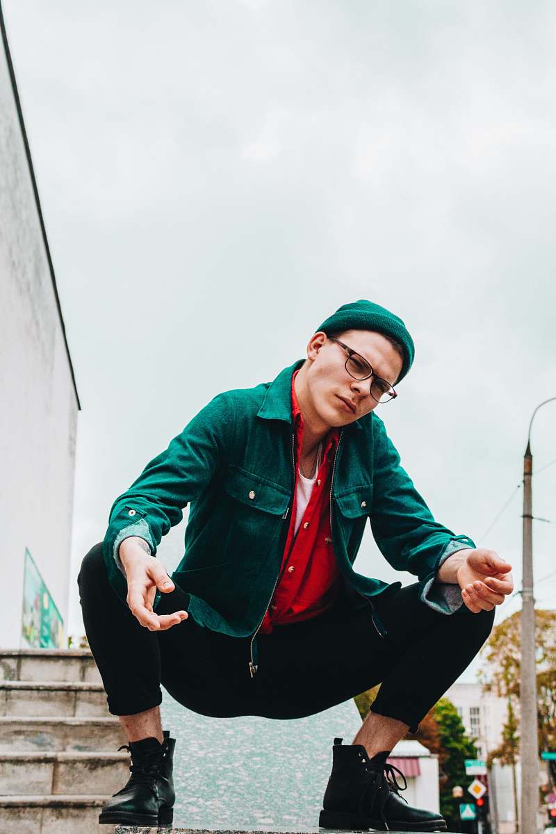 person man wearing green jacket near brown stair human