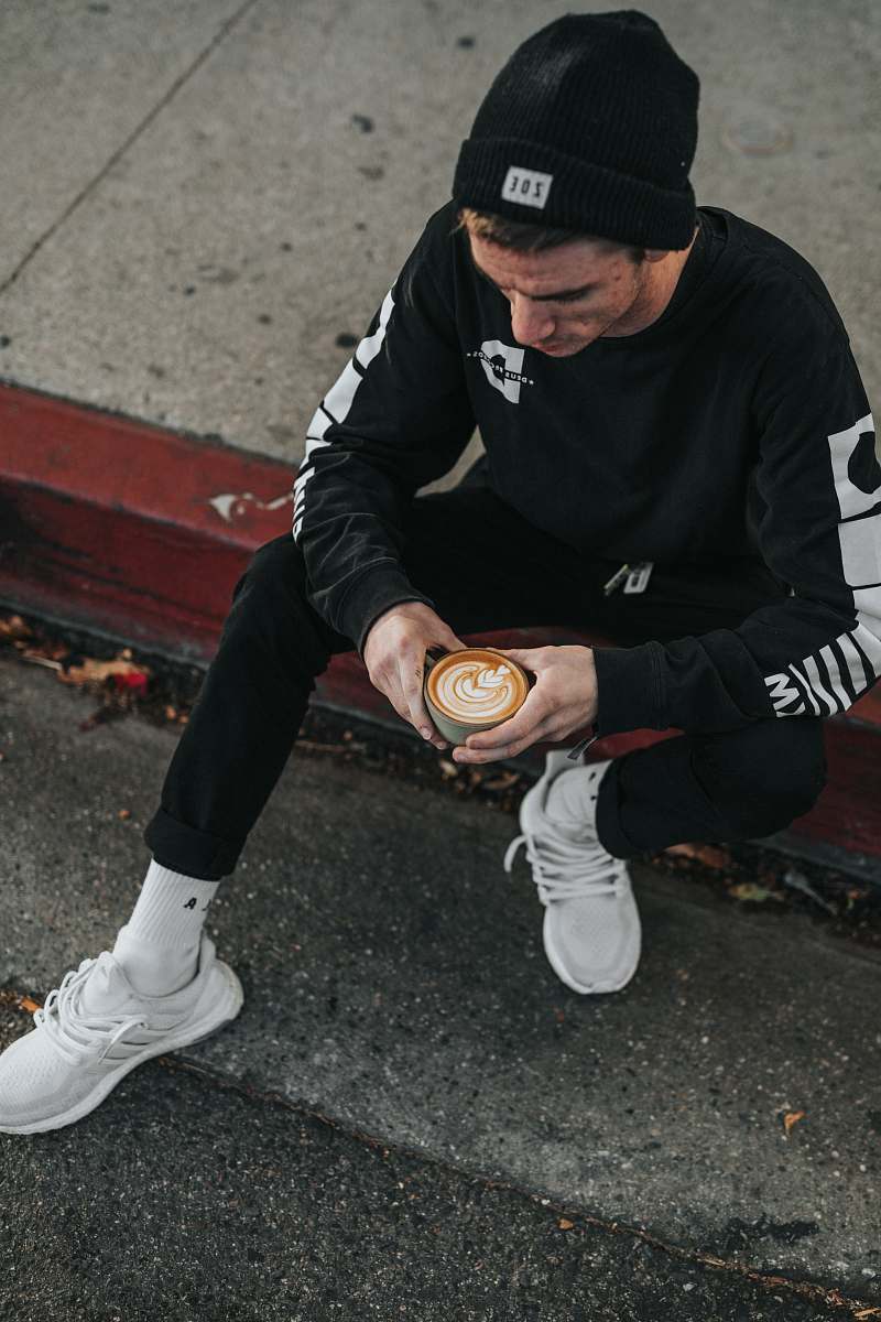 human man wearing hat and sitting on ground person