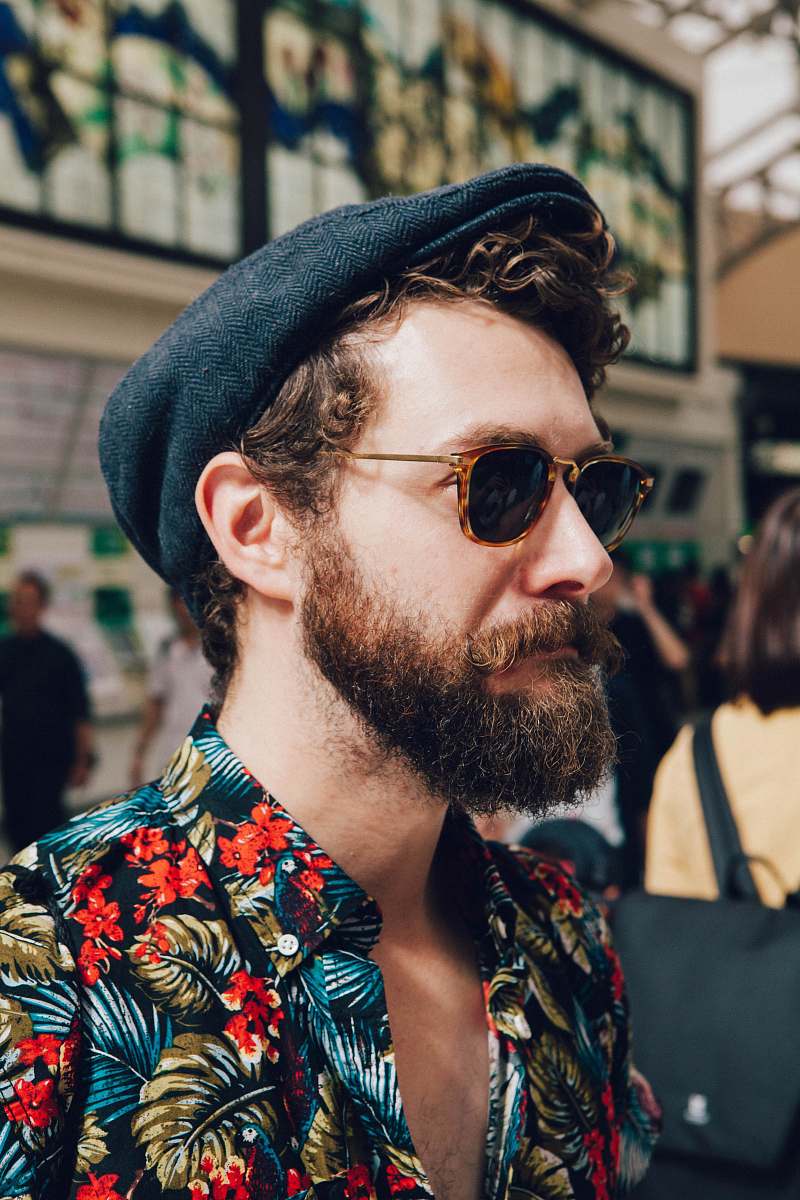human man wearing multicolored floral shirt and black framed black lens sunglasses person