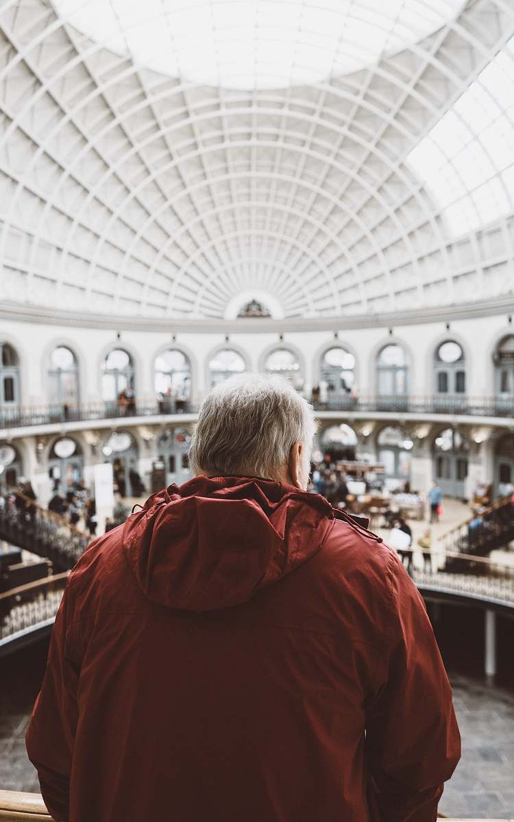 person man wearing red hoodie inside dome building in front of people human