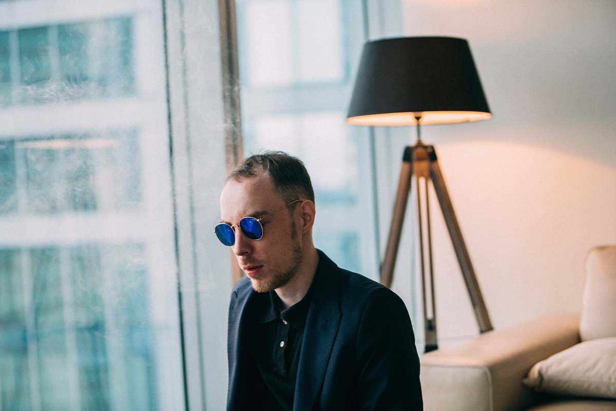 human man wearing sunglasses near table lamp photo person