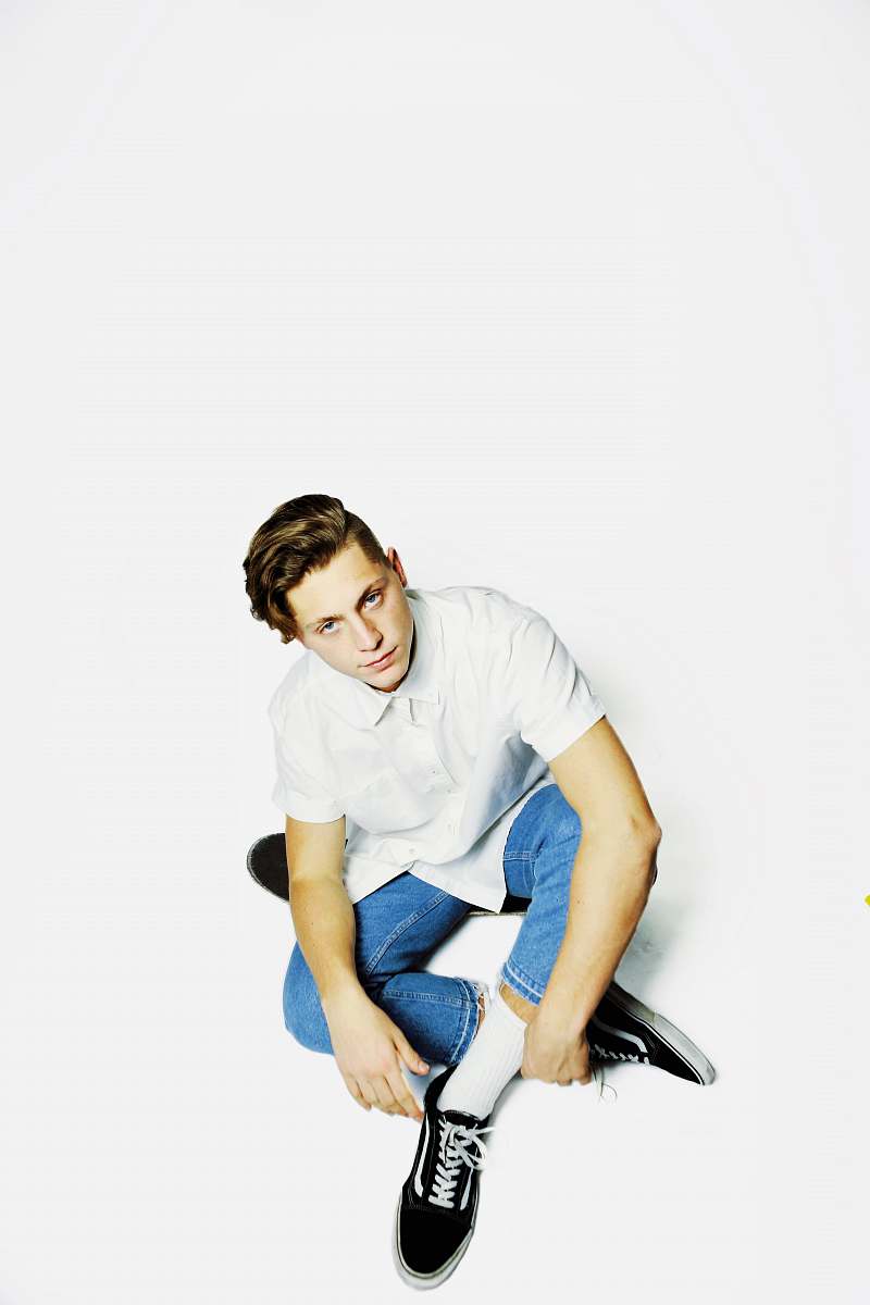 person man wearing white dress shirt and blue denim jeans sitting on floor human