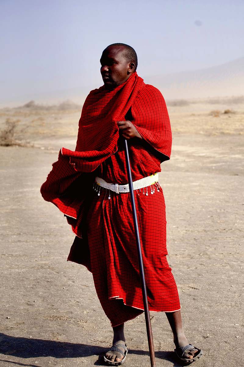 human man with black metal rod standing in dessert during daytime person