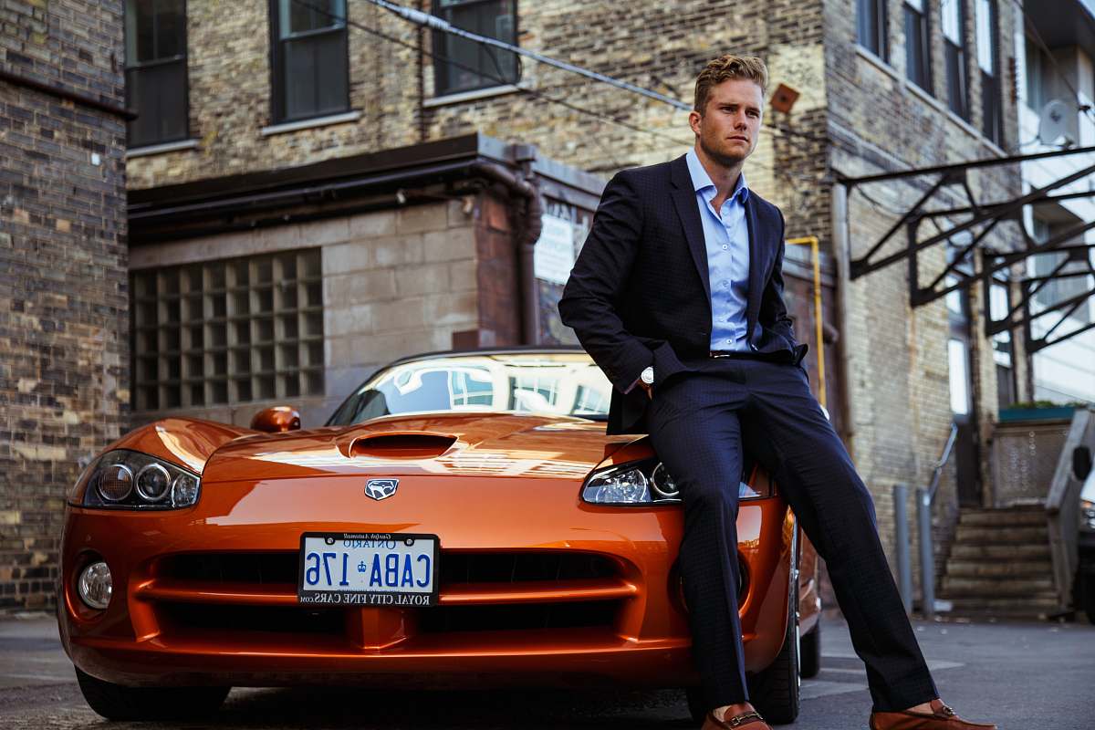 person men's black suit and orange coupe car