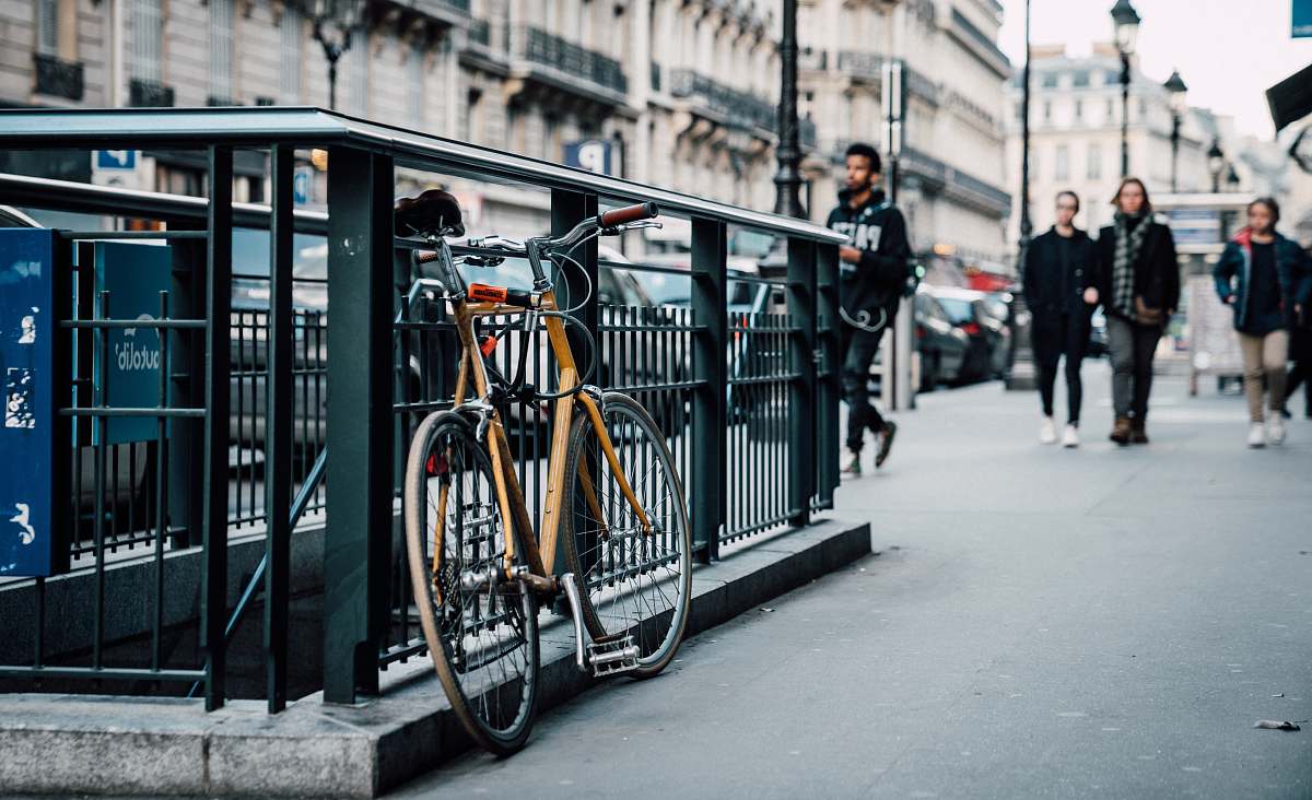 person parked orange bicycle on subway railings bicycle