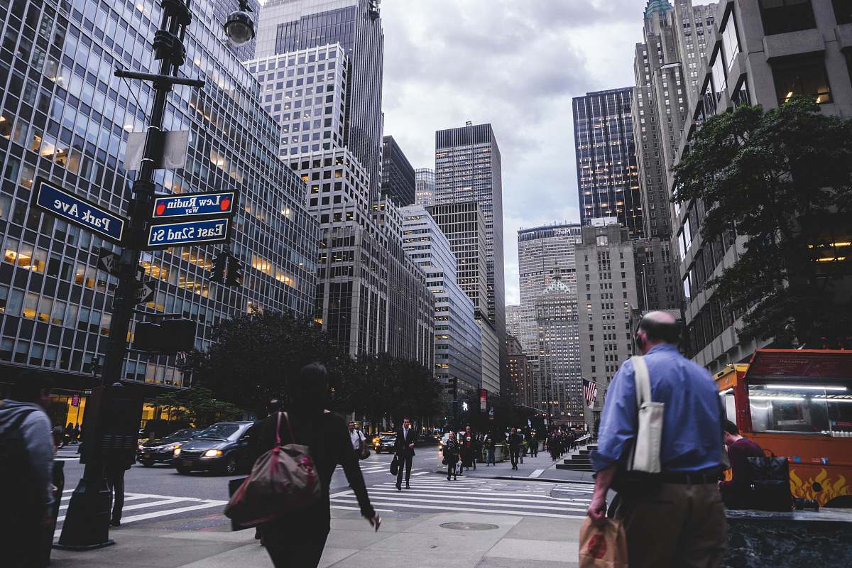 human people passing by black post during daytime photography road