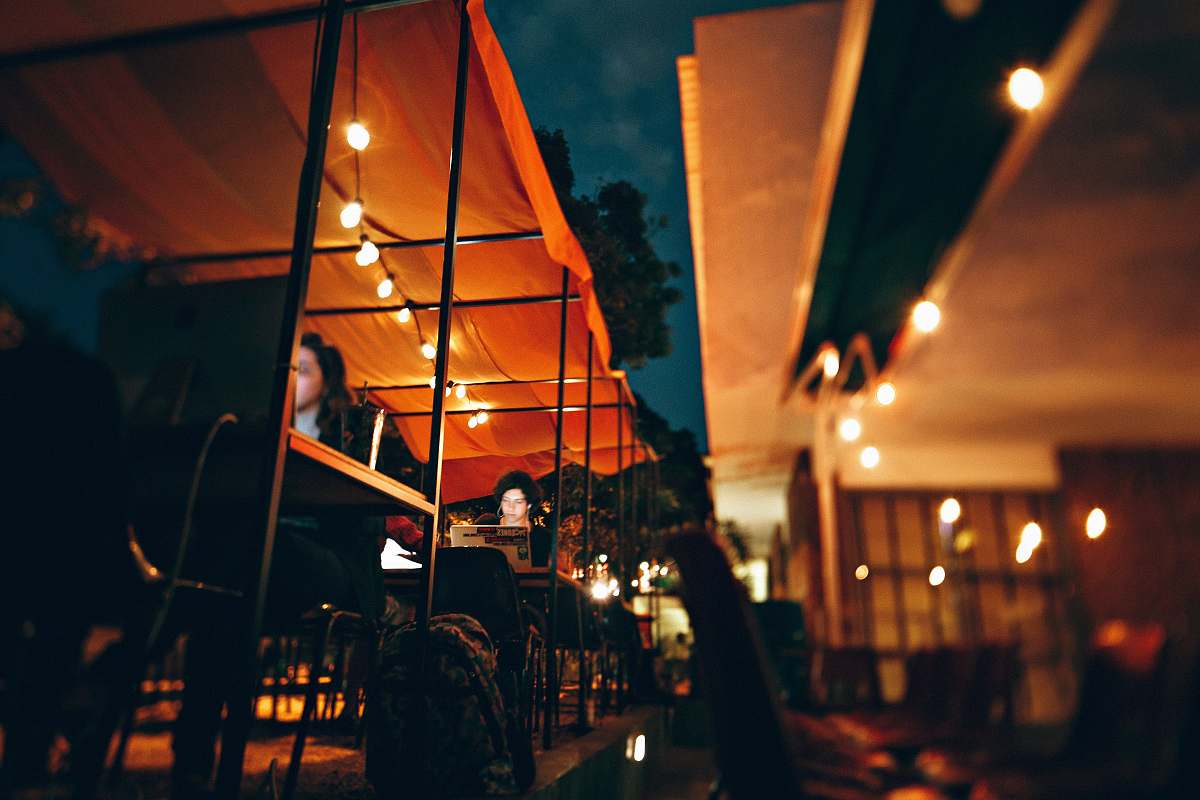 human people sitting on chair outside the restaurant during nighttime person
