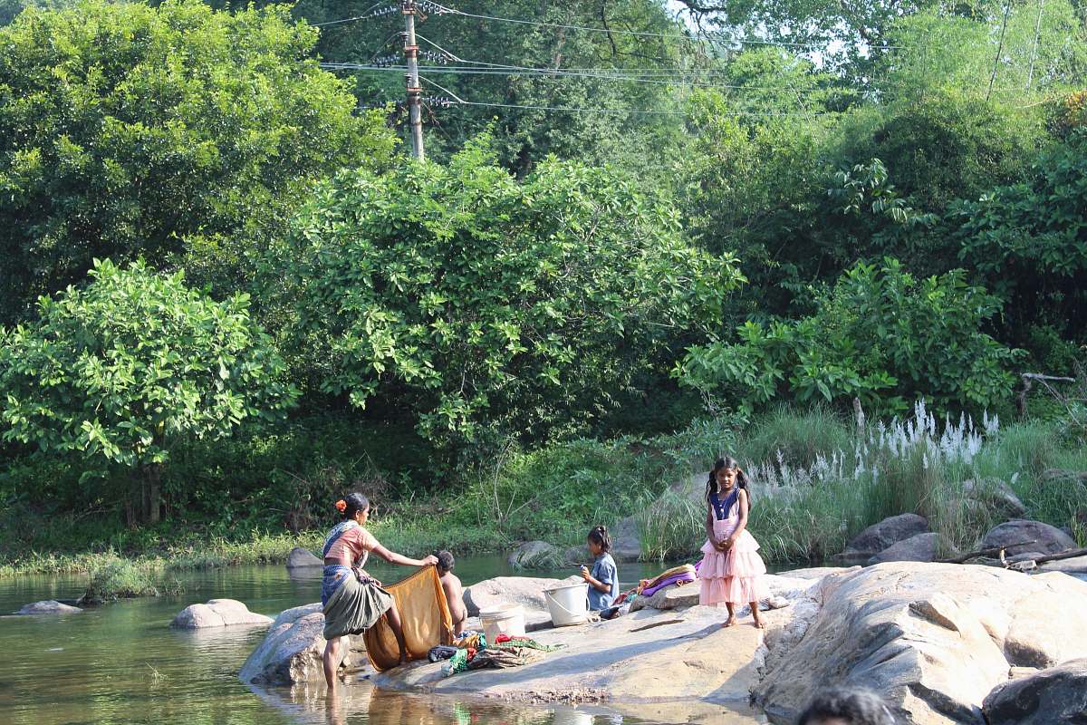 person people sitting on rock beside body of water during daytiem human