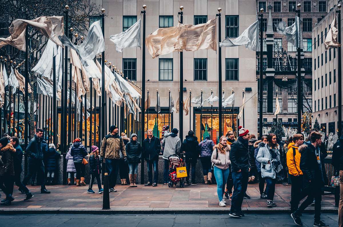 human people standing near white and brown flags during daytime person