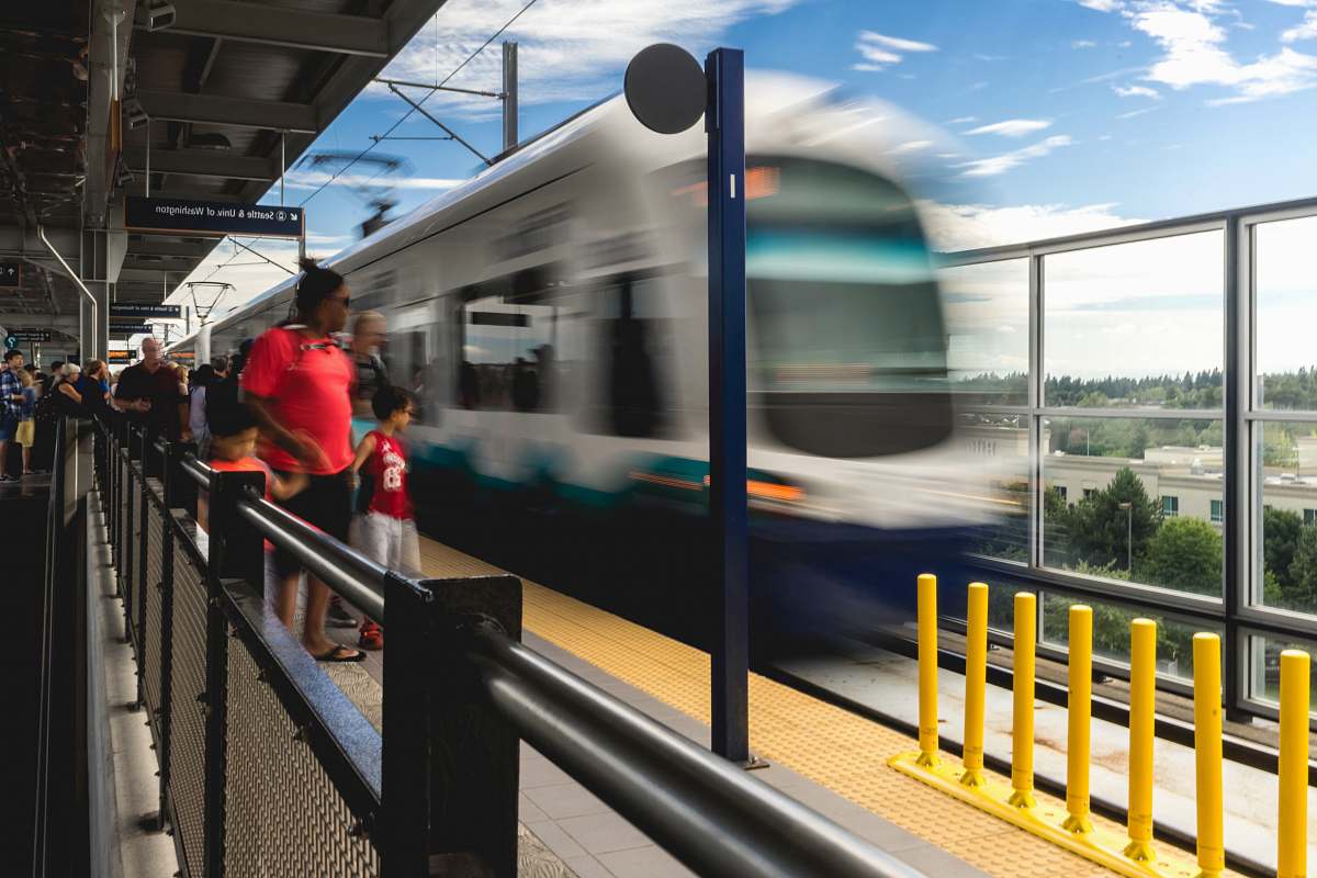 transportation people standing on platform near blue and white train during daytime train