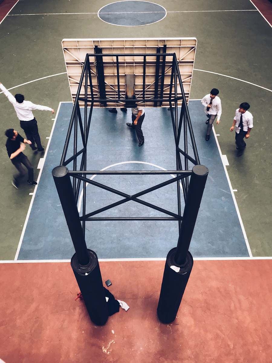 human people standing under basketball hoop person