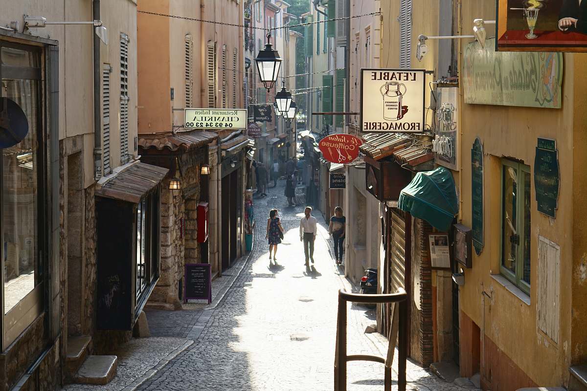 town people walking between buildings street