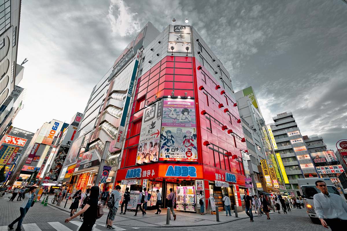 person people walking in front of red high-rise building under gray clouds human