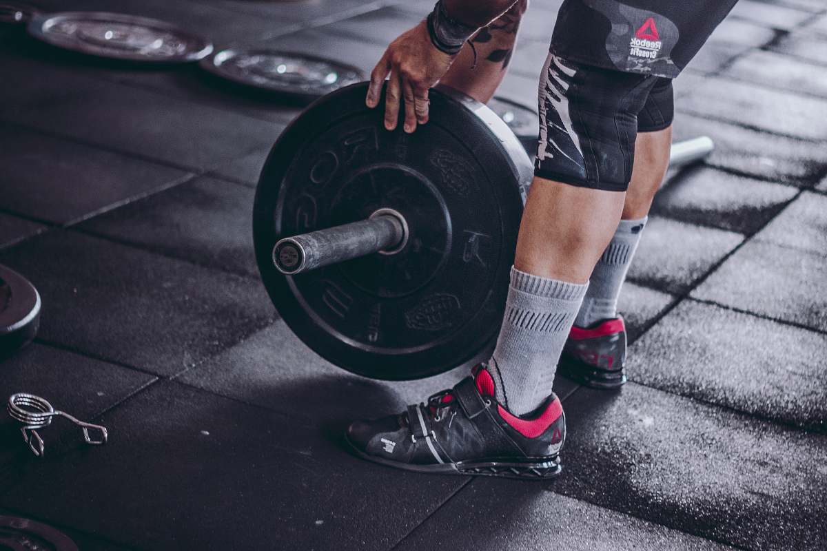 human person holding black barbell plate person