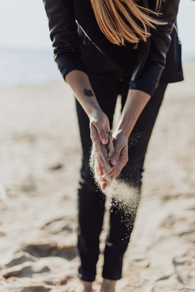 human person holding brown sand during daytime person