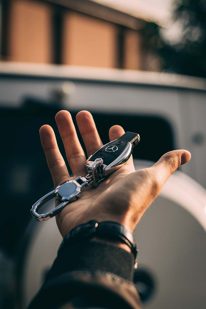 person person holding Mercedes-Benz fob human